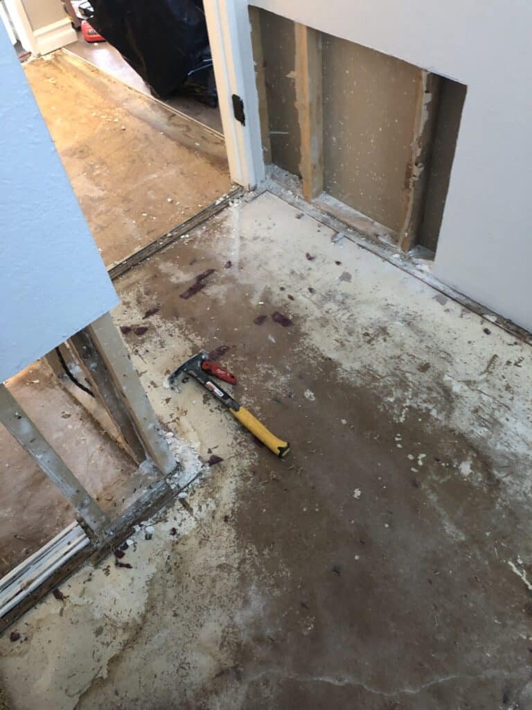 Floor and lower wall materials removed beside a doorway