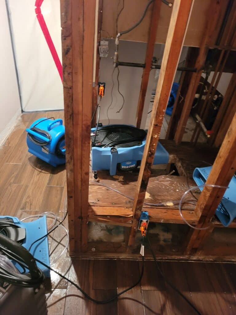 Exposed framing and plumbing beside drying equipment