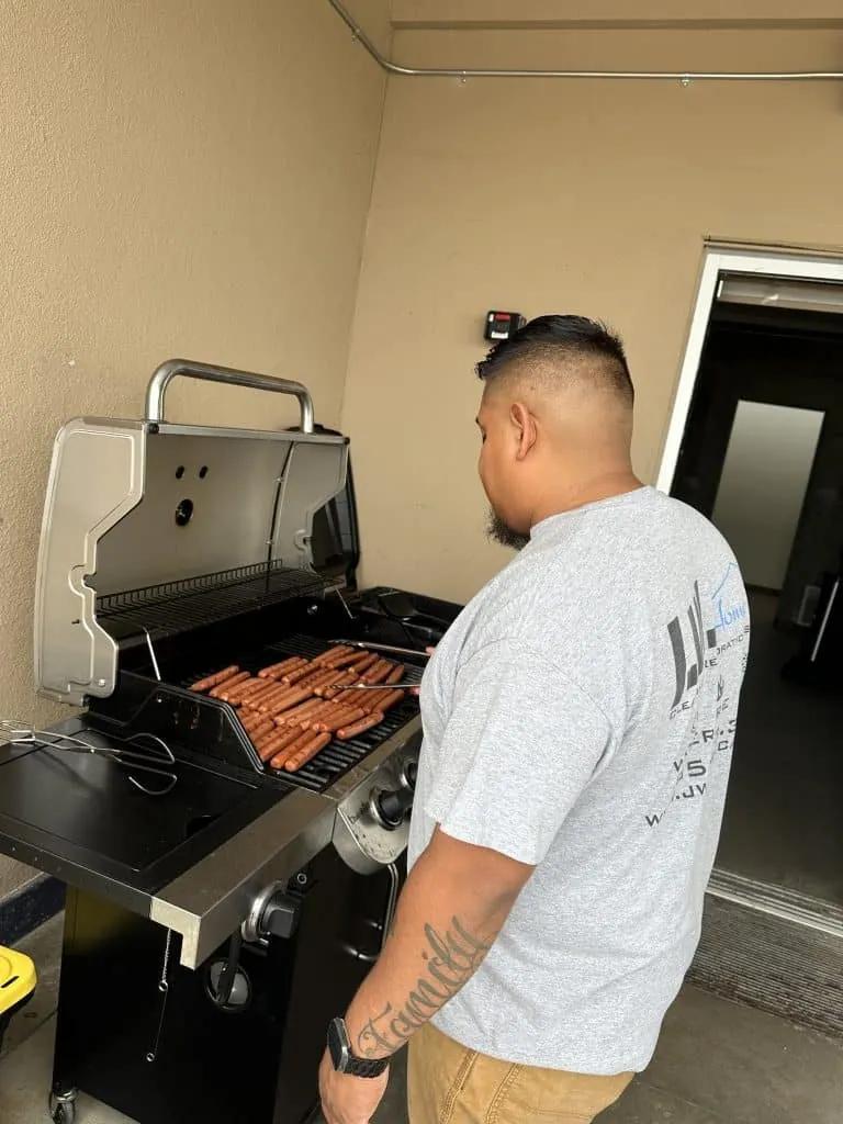 Man grilling hot dogs on a barbecue grill