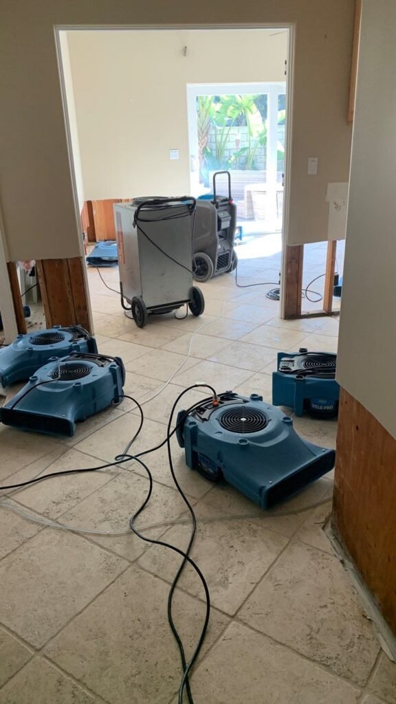 Air movers and a dehumidifier in an opened interior work area
