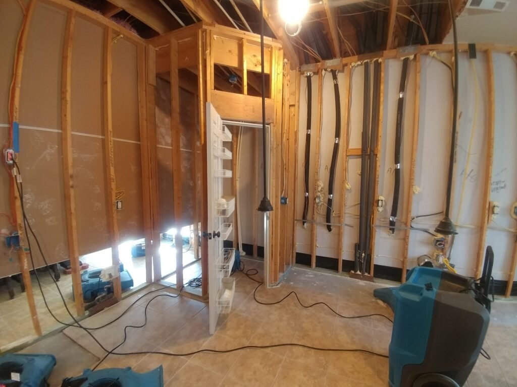 Air movers and dehumidification equipment beside exposed wall framing