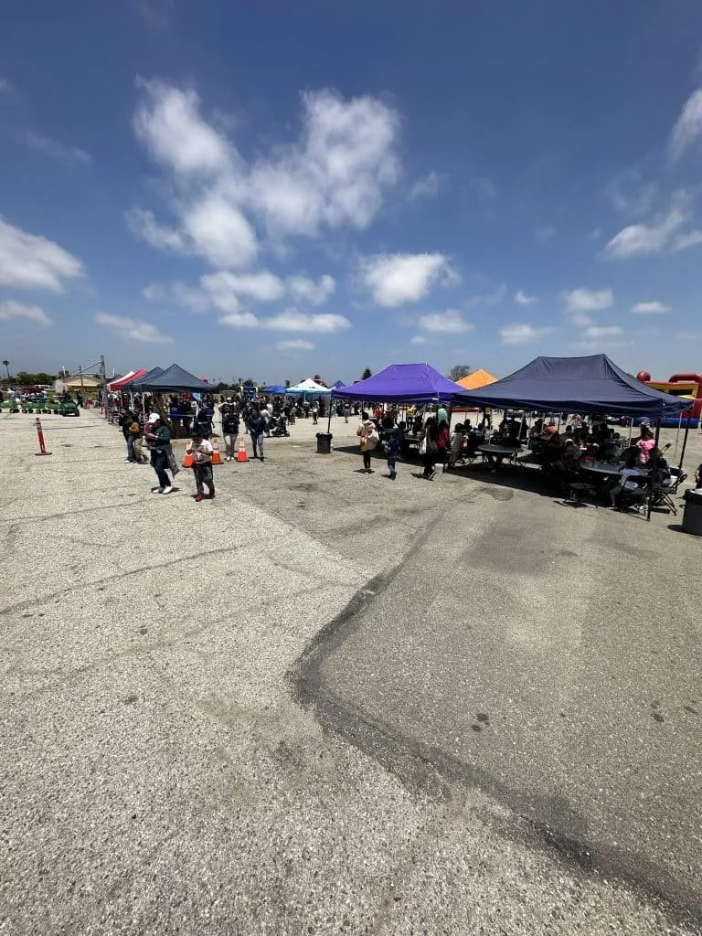 Canopies set up across a parking lot for an outdoor community event