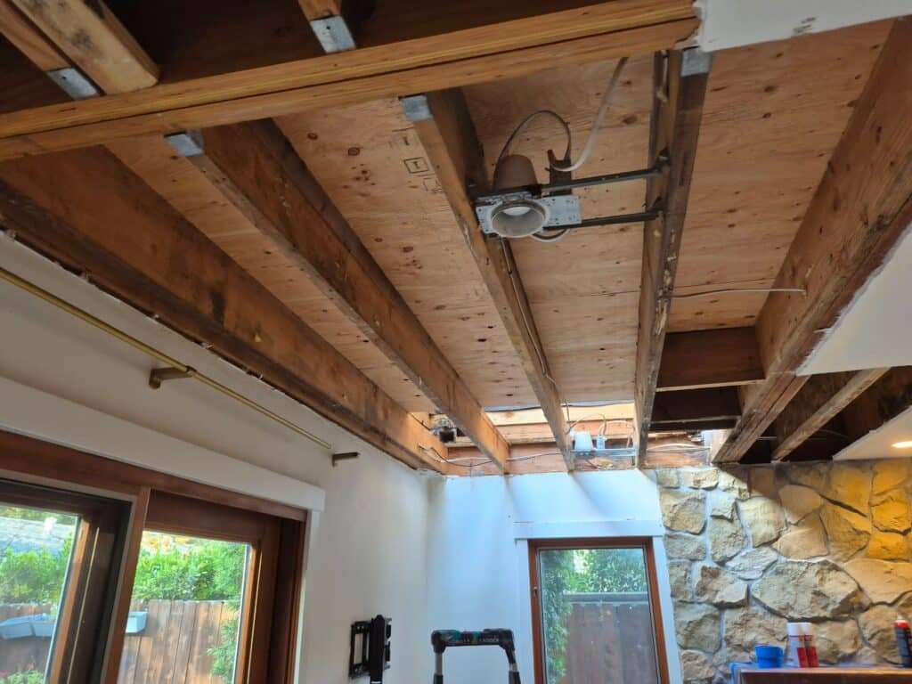Opened ceiling exposing joists above a living room