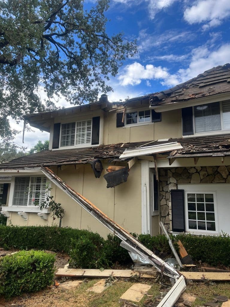 Fallen tree against the roof of a two-story home — Westlake Village
