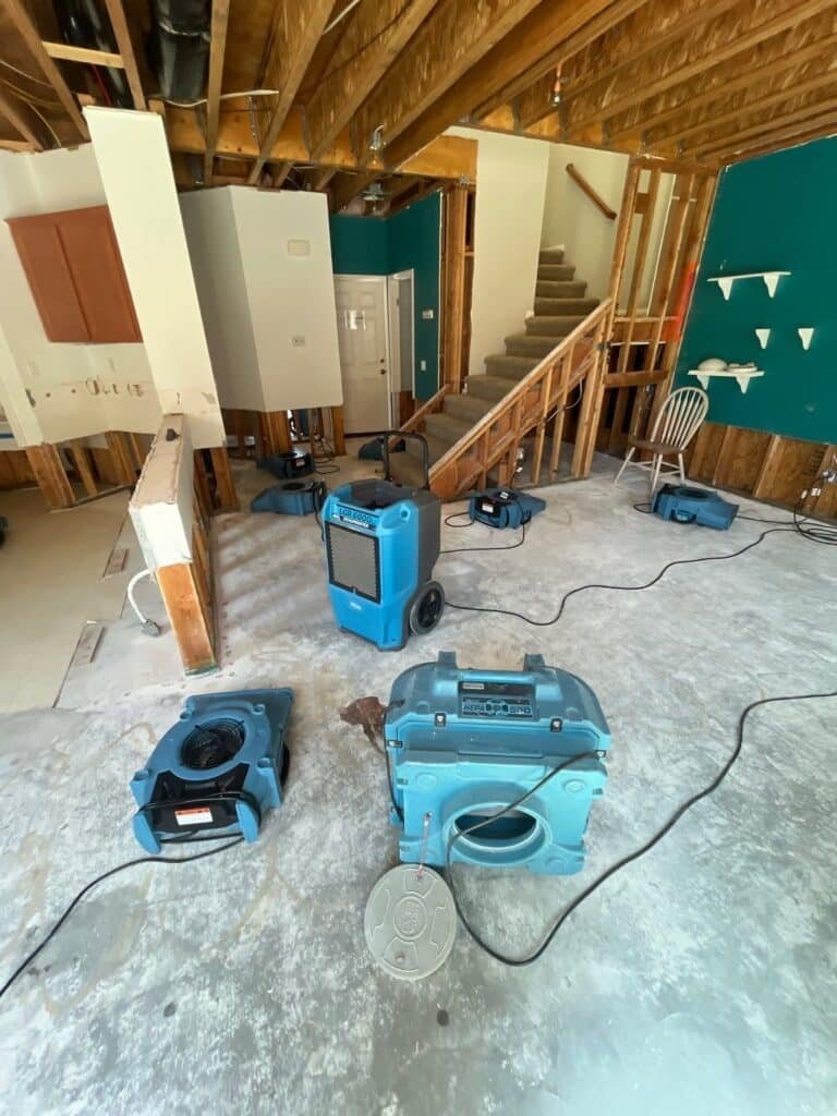 Drying equipment in a room with exposed wall and ceiling framing