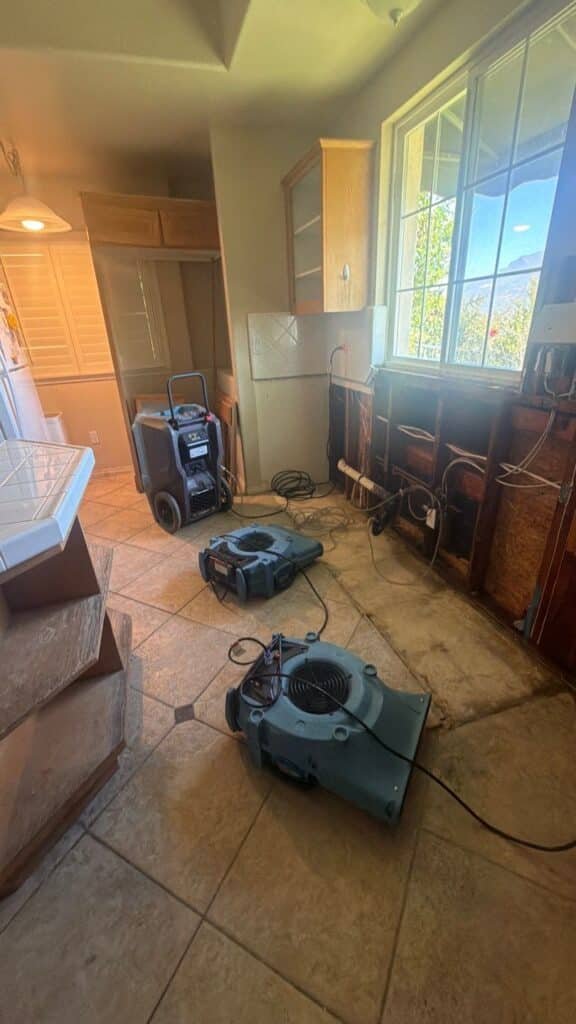 Air movers and a dehumidifier in an opened kitchen work area