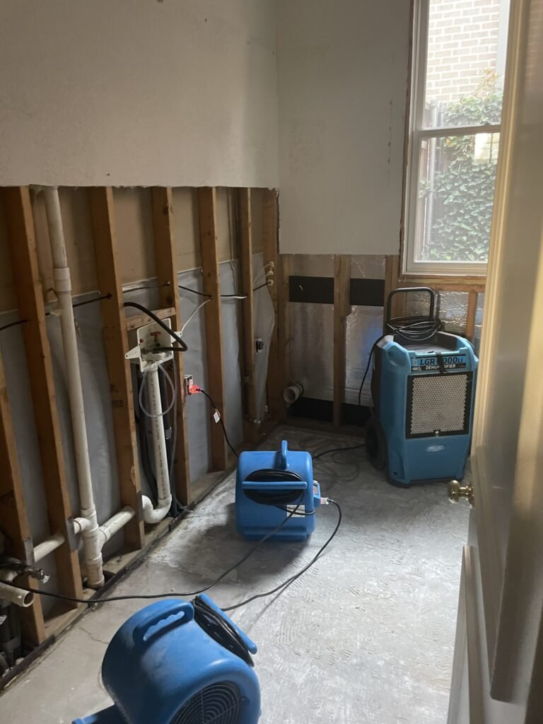 Air movers along exposed lower wall framing