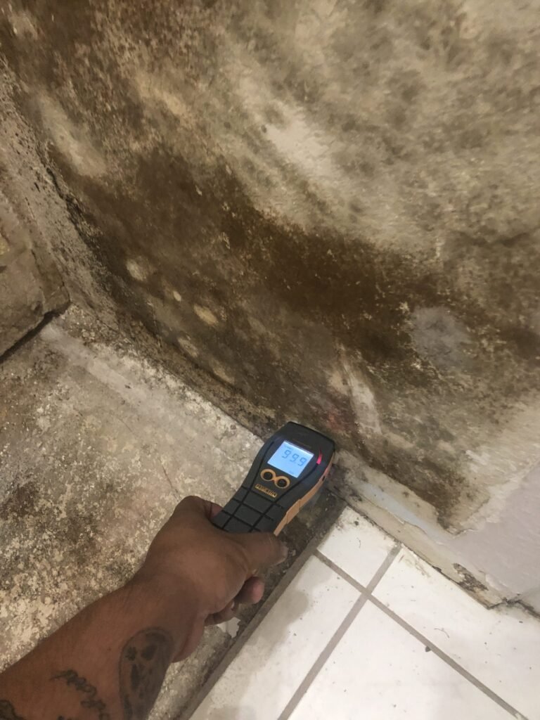 Moisture meter held against discolored wall material — Moorpark