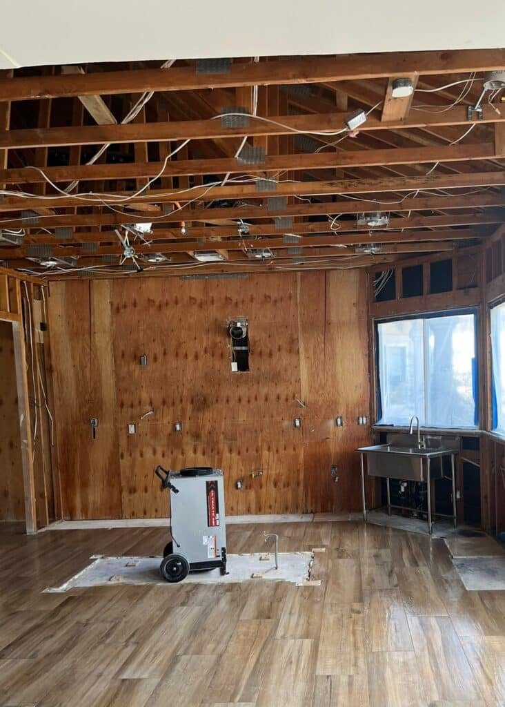 Drying equipment in a room with wall and ceiling framing exposed