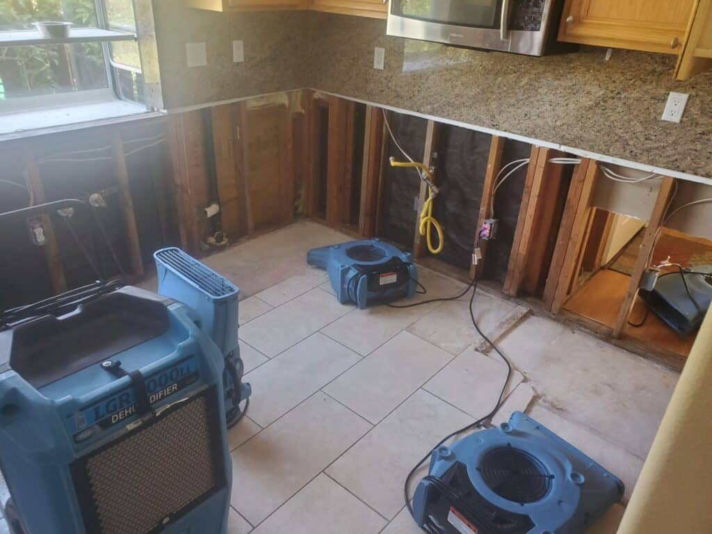 Air movers and dehumidification equipment on a kitchen tile floor