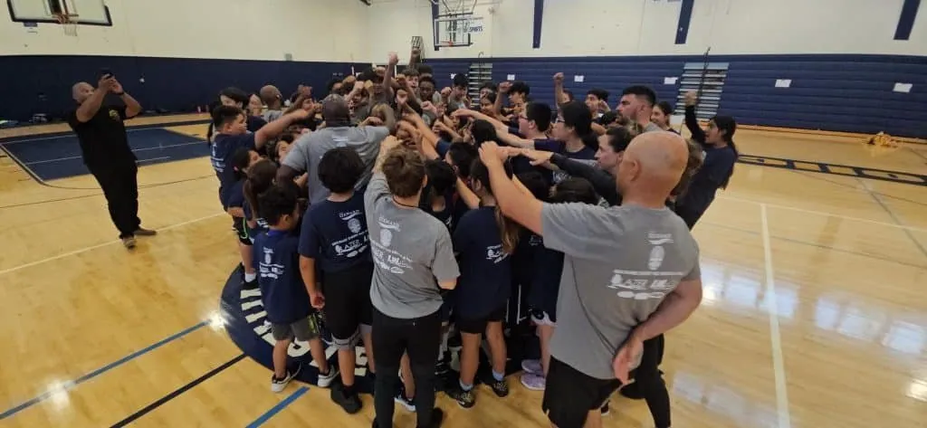 Youth basketball players huddled together in a gym