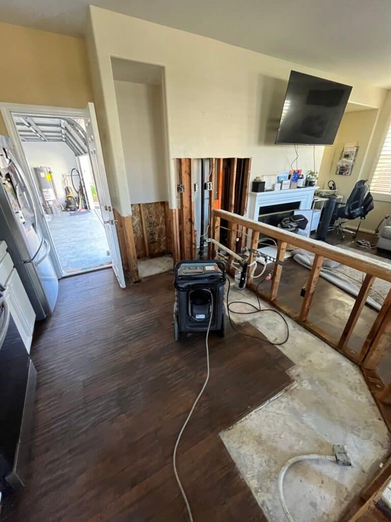 Dehumidifier in a living area with lower wall materials removed