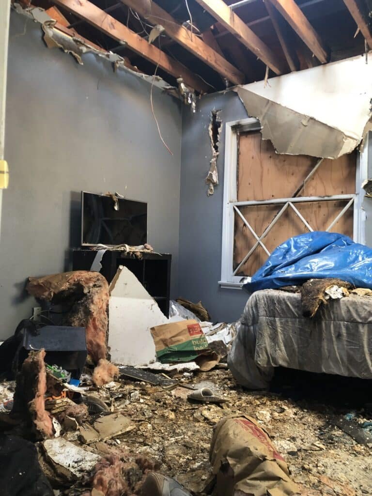 Fire-damaged room with exposed ceiling framing and debris