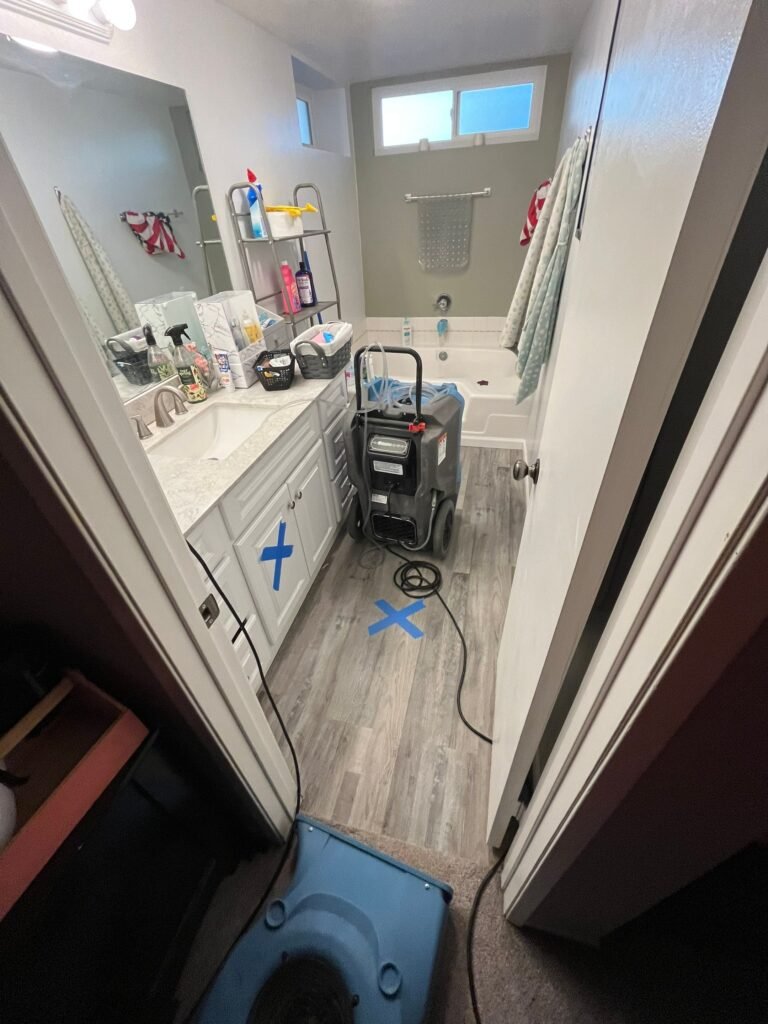 Air movers and a dehumidifier beside an opened bathroom vanity area — Santa Barbara